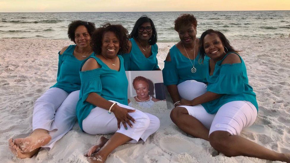 Photo of the Sensational Six on the beach in Florida, holding a photo