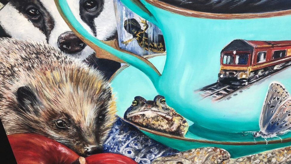 Close up shot showing some of the detail in the painting, with a hedgehog, badger, frog, snake, butterfly and a teacup with a train on a railway track