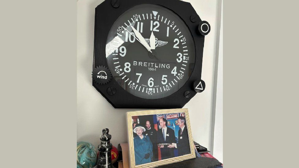Image of the control centre clock and a photo of Queen Elizabeth II meeting the team at Cameron Balloons.