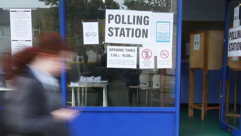 A girl walking past a polling station
