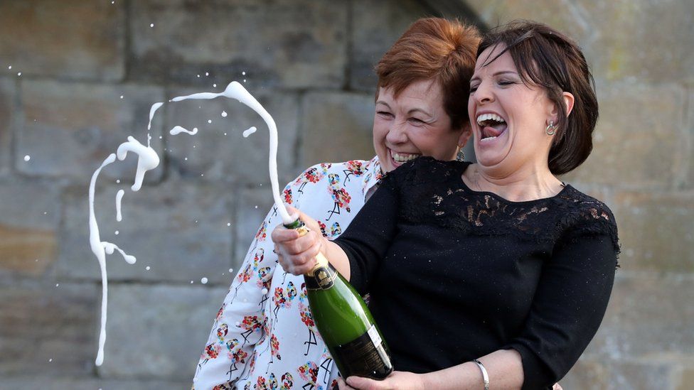 Paula Barraclough, left, and Lorraine Smith celebrate their Lotto win with a bottle of Champagne
