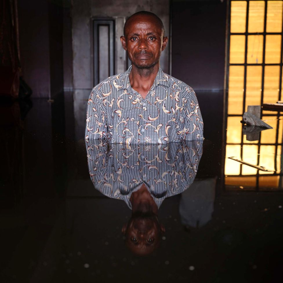 Христиан-алавей стоит в наводнении в своем доме в муниципалитете Огбия, штат Байелса, Нигерия, ноябрь 2022 г.