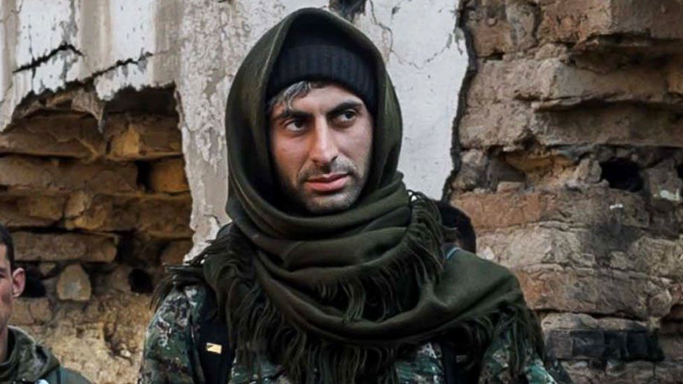 Johan Cosar is photographed in military fatigues with a scarf wrapped around his head