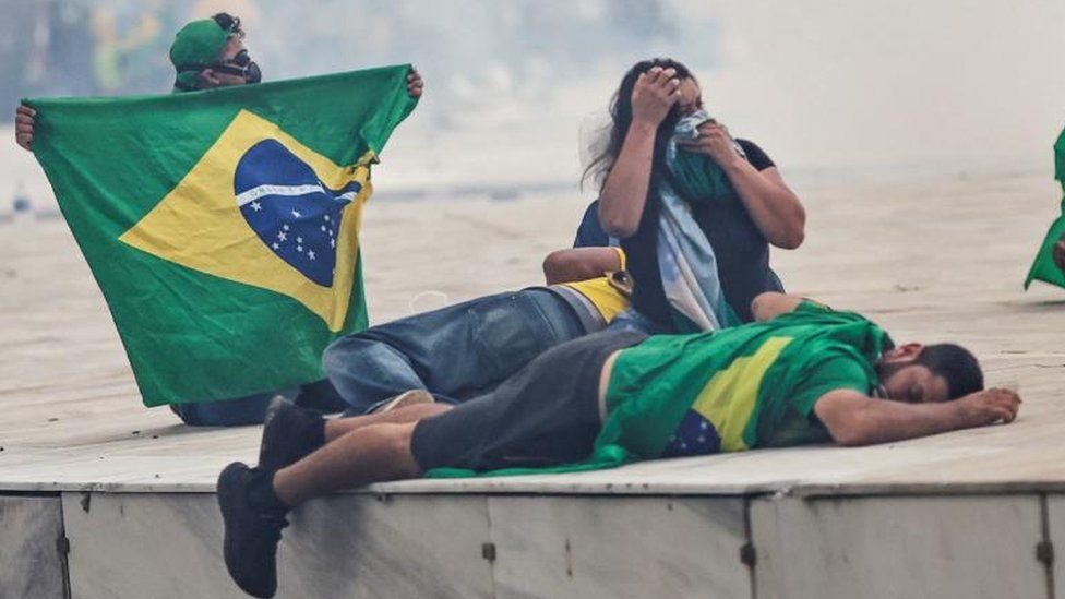 Сторонники бывшего президента Бразилии Жаира Болсонару реагируют на демонстрацию против президента Луиса Инасио Лулы да Силвы у дворца Планалто в Бразилиа, Бразилия, 8 января 2023 г.