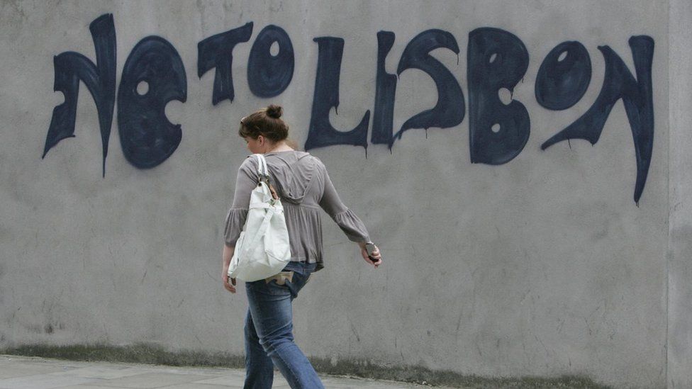 A woman walks past graffiti in Dublin, on June 13, 2008.