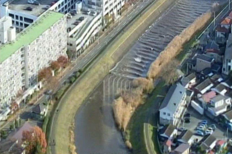 In this image made from video released by Miyagi Prefectural Police, the water flows up river in the Sunaoshi River in Tagajo, Miyagi prefecture, northern Japan, as a tsunami warning is issued following a strong earthquake Tuesday, 22 November 2016.