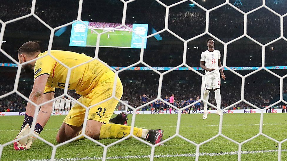 Italy's Gianluigi Donnarumma saves a penalty from England"s Bukayo Saka to win the penalty shoot-out
