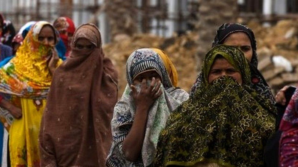 Women stand in a queue to get food distributed by the Saylani Welfare Trust during a government-imposed nationwide lockdown as a preventive measure against the COVID-19 coronavirus in Karachi on March 26, 2020.