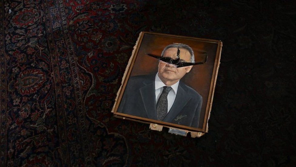 A vandalized painting depicting a political figure lies on a room at the National Congress