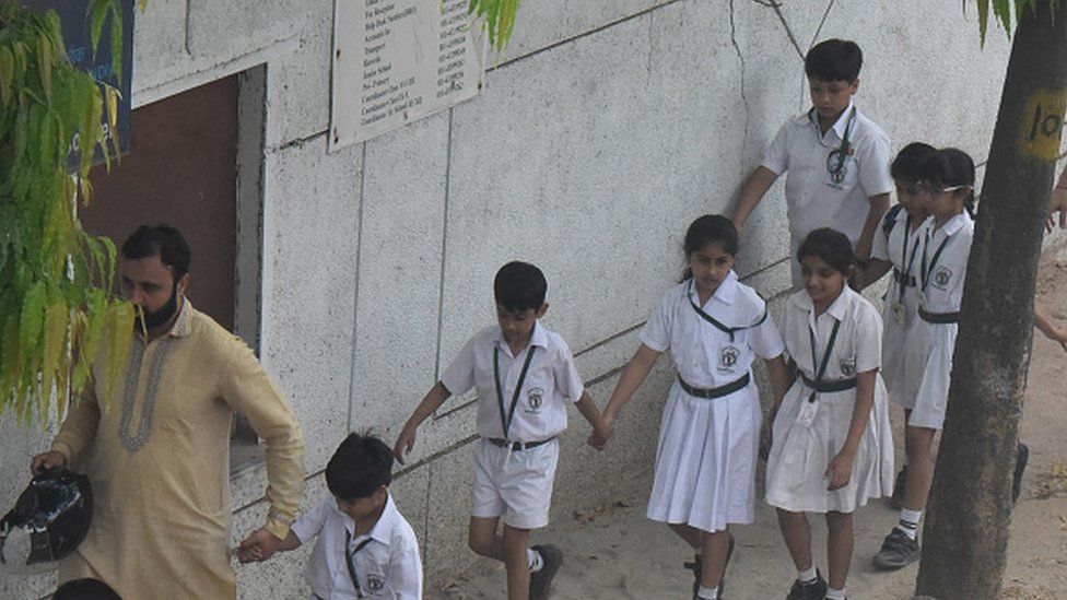 Parents with their children leave after receiving a bomb threat, at Delhi Public School (DPS), Mathura Road, on April 26, 2023