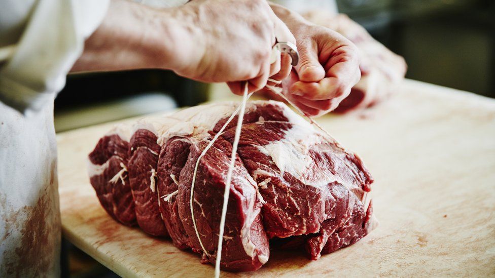 Beef joint being prepared by a butcher