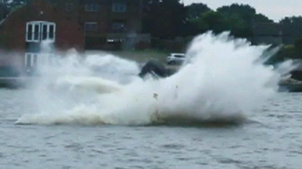 Powerboat flipping over in the water.