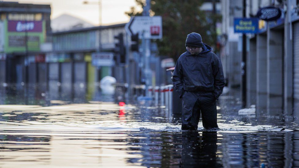 Man walks through flooded water in Downpatrick