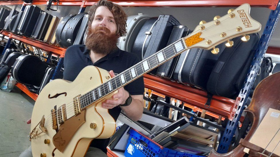 Auctioneer Luke Hobbs with the Gretsch White Falcon guitar