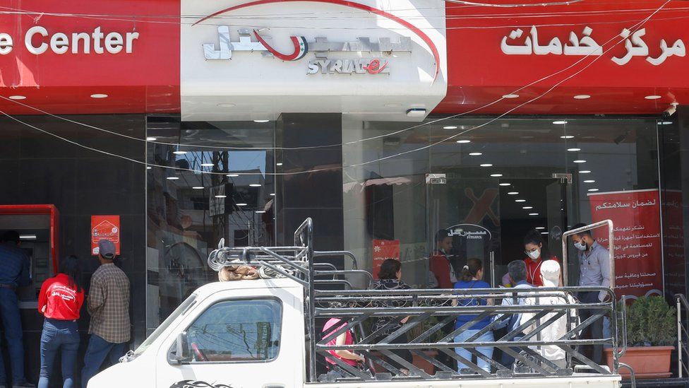 Customers queue outside a shop operated by Syriatel in Damascus, Syria (11 May 2020)