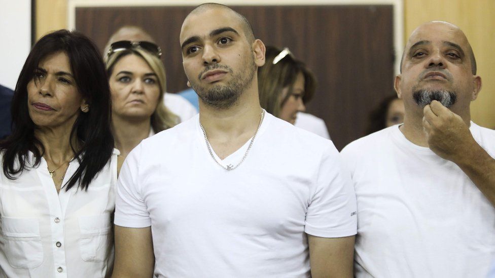 Israeli soldier Elor Azaria (C), who shot dead a wounded Palestinian assailant in March 2016, stands next to his mother Oshra (L) and father Charlie - 30 July 2017