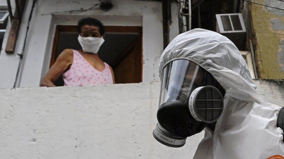 File photo shows a poor resident, identity disguised, looking down at someone in specialised PPE