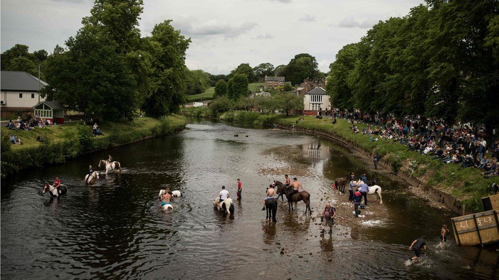 People wash horses in the River Eden on the second day of the annual Appleby Horse Fair