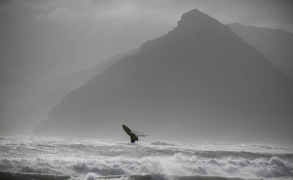 Windsurfer Jake Kolnik sails during a storm in Cape Town, South Africa 07 June 2017. A powerful storm with gale force winds, heavy rain and seas in excess of 10 meters lashed the peninsula causing damage to property and vegetation.