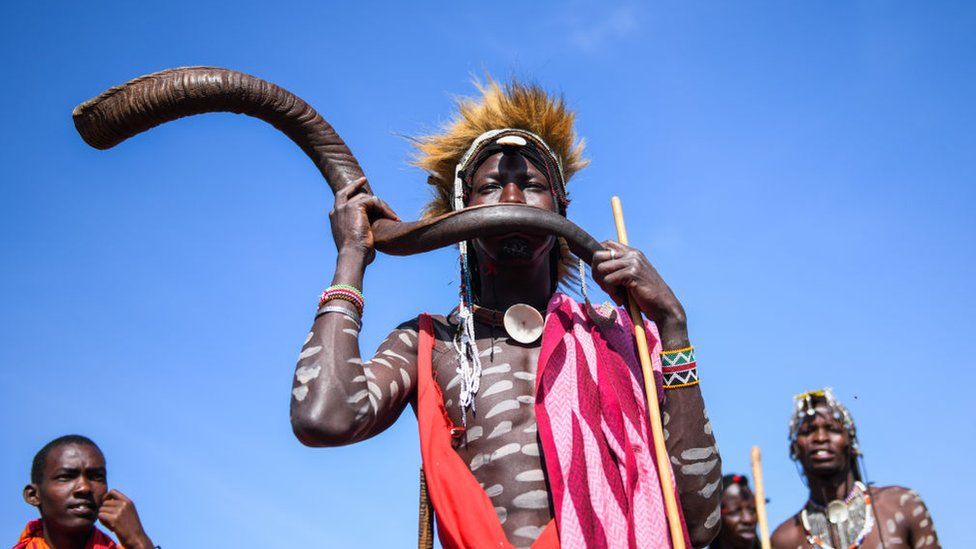 Maasai man playing traditional instrument, 8 August 2023