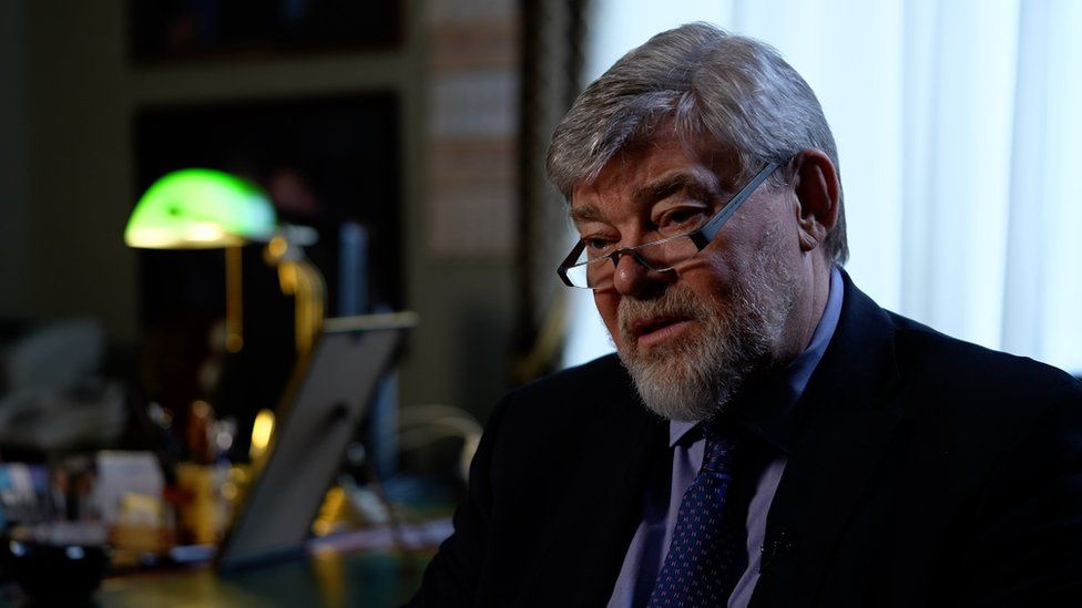 Konstantin Remchukov, Chief Editor, Nezavisimaya Gazeta, sits in front of a desk.