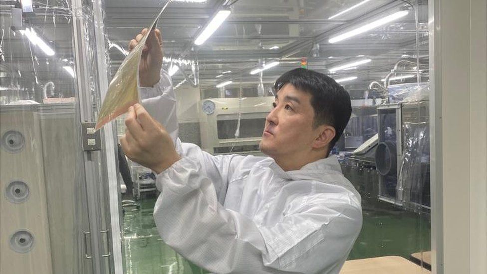 Enecoat Technologies boss Naoya Kato looking at the company's ultra-thin solar sheet