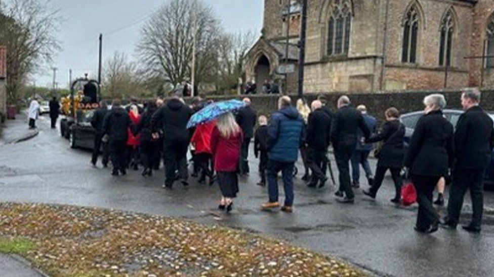 Mourners walked behind the dumper truck at Mr Newton's funeral