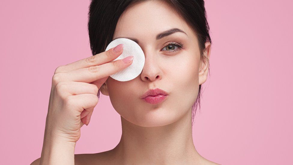 Stock image of a woman using a cotton make-up removal pad