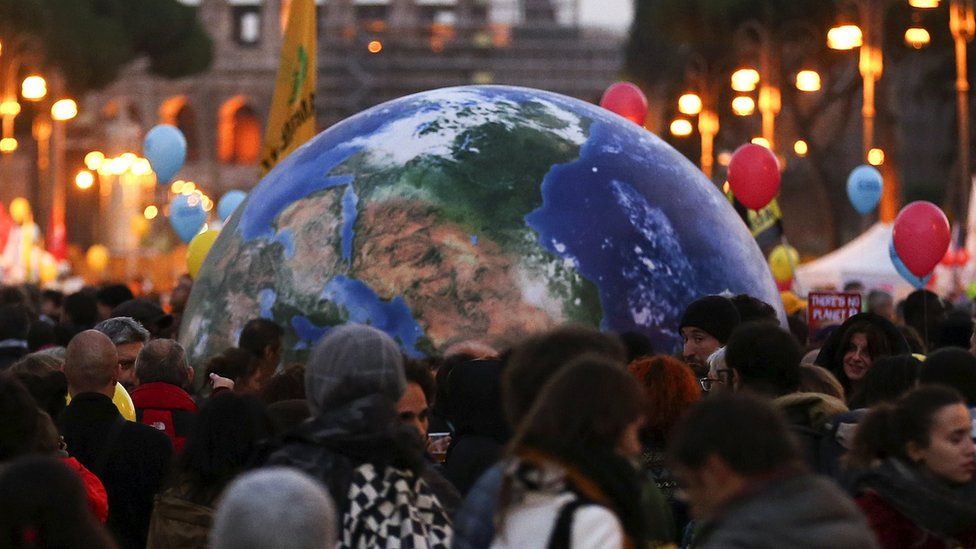 Protesters carry a globe-shaped balloon in front of Rome"s Colosseum during a rally held the day before the start of the 2015 Paris Climate Change Conference (COP21), in Rome, Italy, November 29 2015