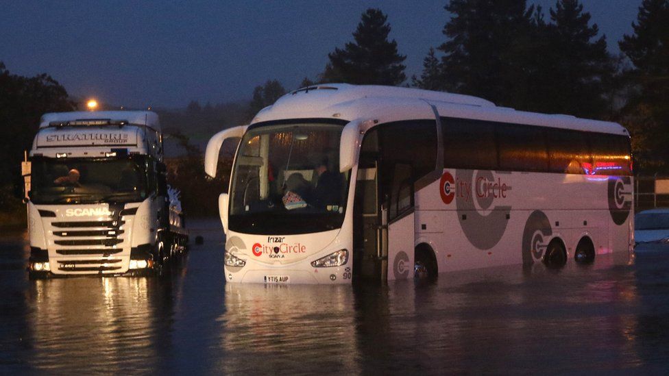 Bus and lorry in water at Oban
