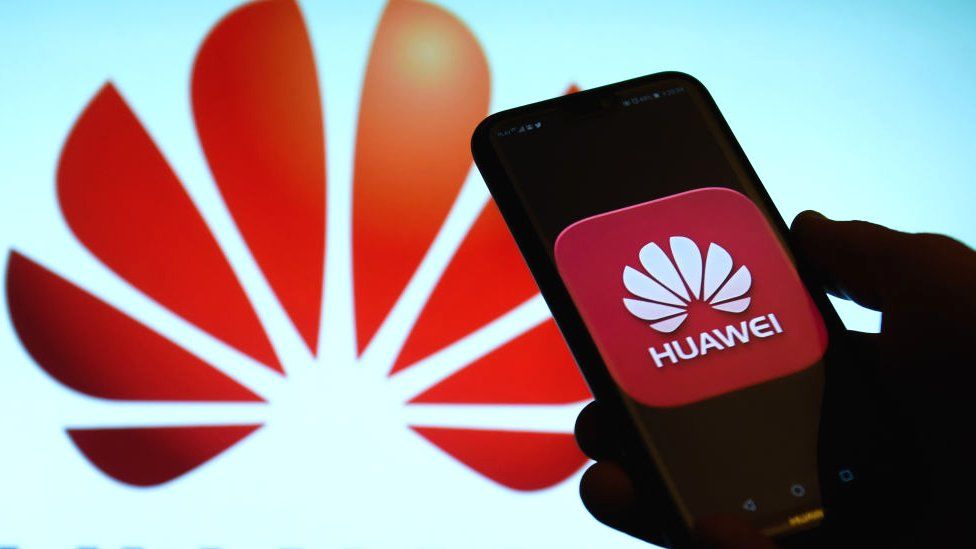A Huawei phone in front of the company logo