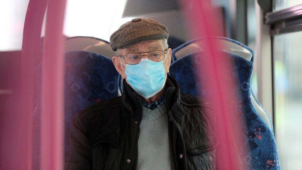 A elderly man wears a protective face mask on a bus in Belfast