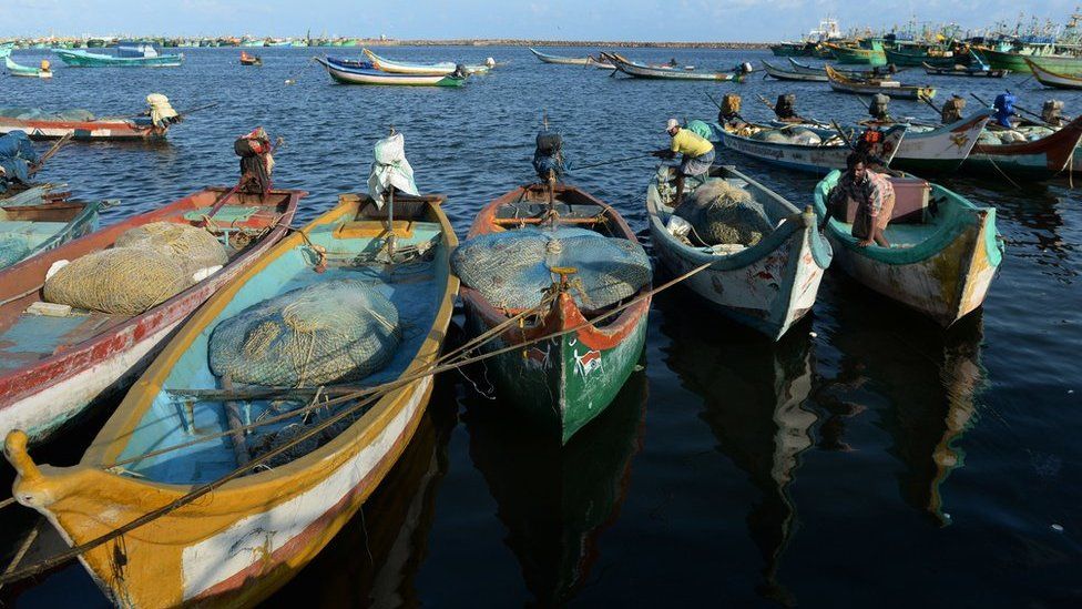 Indian fishermen arrive at a harbour after a night working at sea in Chennai