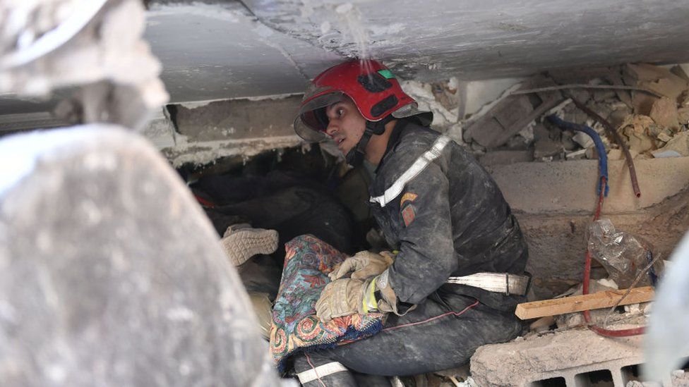 Rescuer trying to help people under the rubble