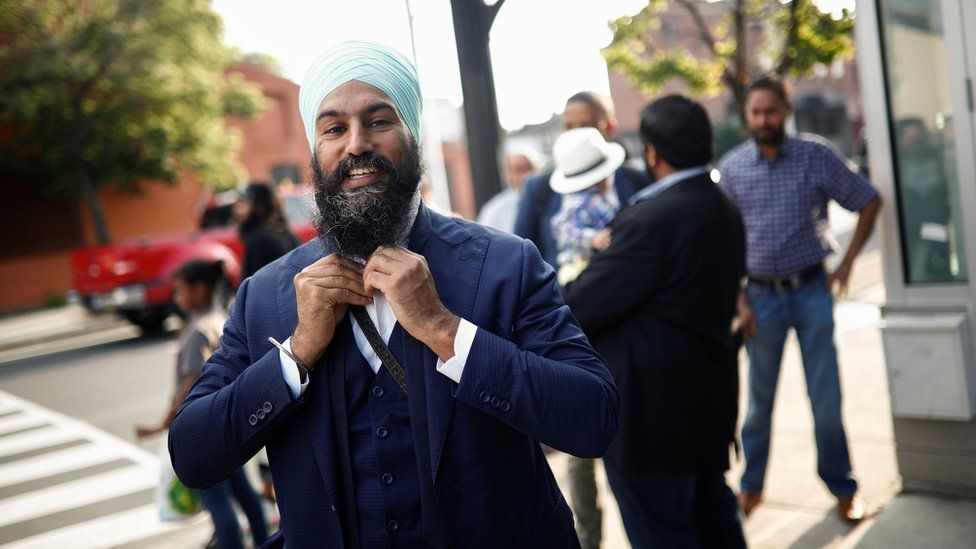 New Democratic Party leadership candidate Singh puts on his tie at a meet and greet event in Hamilton