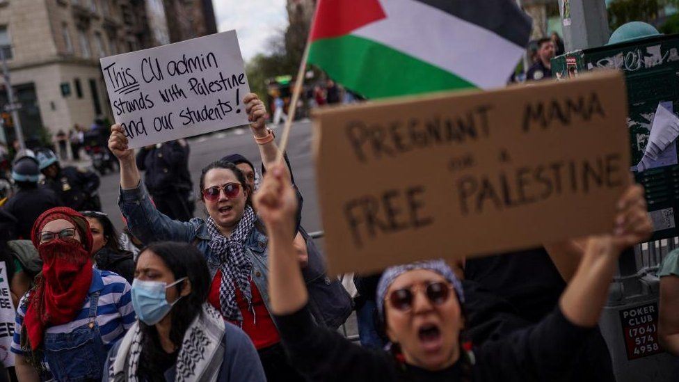 Protesters carry pro-Palestine placards and Palestinian flags