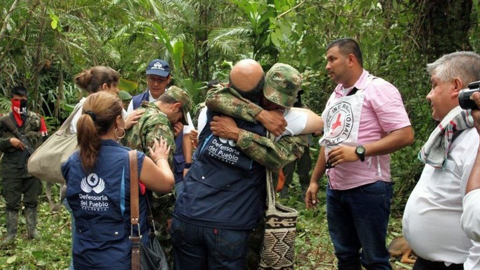 Handout photo released by the Defensoria del Pueblo de Colombia of Colombian soldiers Andres Felipe Perez (C-L) and Kleider Antonio Rodriguez (C-R) embracing representatives of the commission to which they were handed by the ELN guerrilla on November 16, 2015