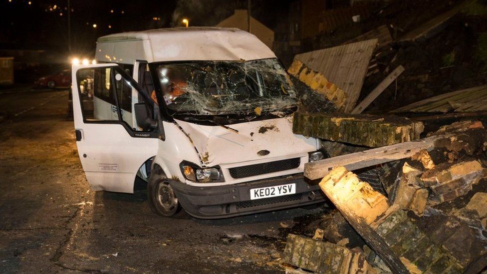 A van covered in rubble