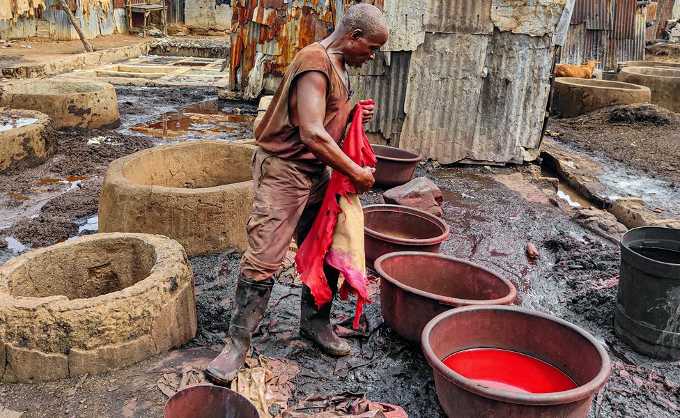 A tannery worker near pots of red dye in Kano, Nigeria - Sunday 13 August 2023