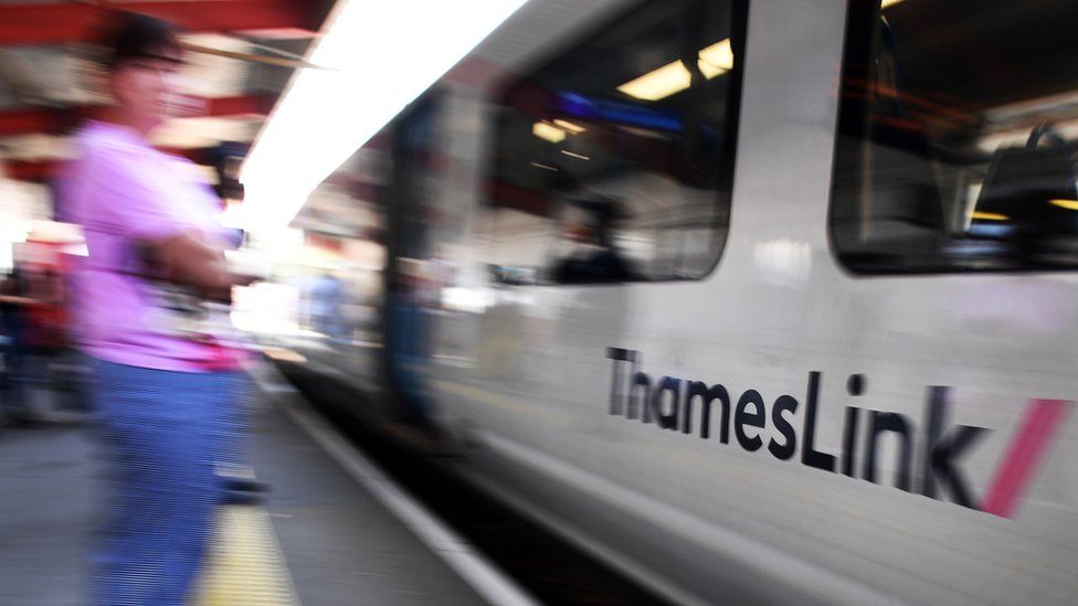 A Thameslink train passes passengers