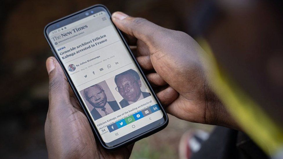 A man looks at his smartphone in Kigali, on May 18, 2020, showing the arrest of Felicien Kabuga, wanted over the 1994 Rwandan genocide