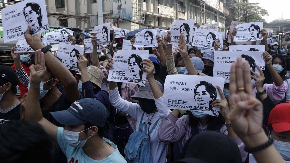 Demonstrators hold placards showing the image of detained Myanmar leader Aung San Suu Kyi in Yangon