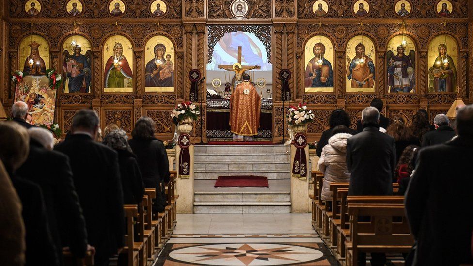 Worshippers attend Christmas Morning mass at a Syriac Orthodox Church in Syria"s northern city of Aleppo