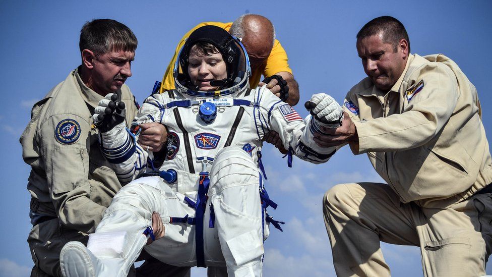 Ground personnel help NASA astronaut Anne McClain to get out of the Soyuz MS-11 capsule shortly after landing in a remote area outside Zhezkazgan, Kazakhstan June 25, 2019.