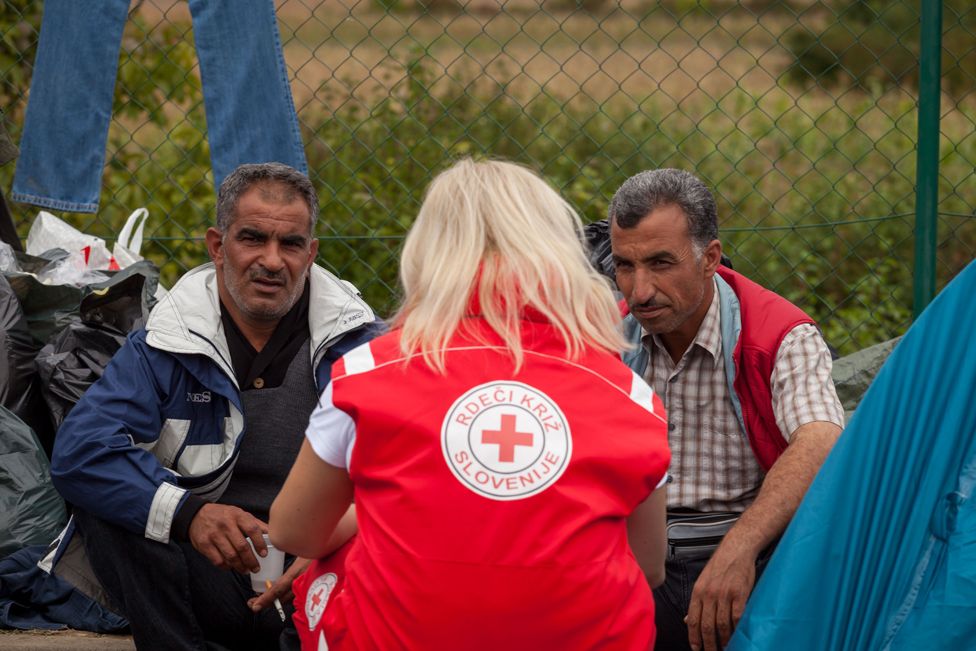 An aid worker with migrants on the Croatian border with Slovenia