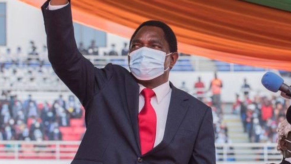 Новоизбранный президент Замбии Хакаинде Хичилема машет толпе после принесения присяги на стадионе Героев в Лусаке 24 августа 2021 года.