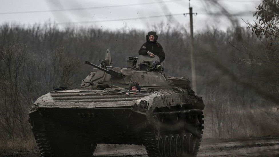 Ukrainian servicemen on a BMP-2 tank drive towards Bakhmut on 11 March