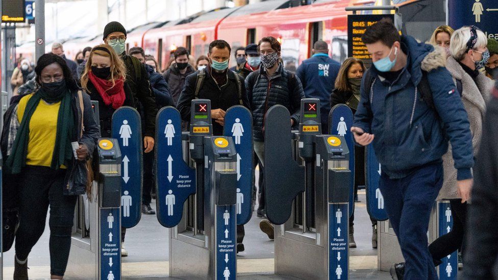Commuters wear facemasks as they walk at Waterloo Station
