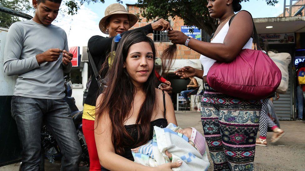 jovem corta o cabelo na fronteira da Venezuela com a Colômbia
