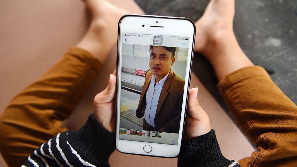 A child looks at a photograph of his 37-year old father Bui Phan Thang